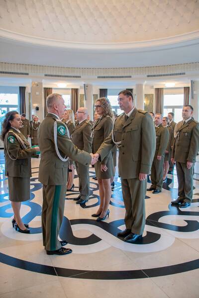 Narodowe Święto Niepodległości Komendant Biura gratuluje funkcjonariuszowi, uciskając dłoń